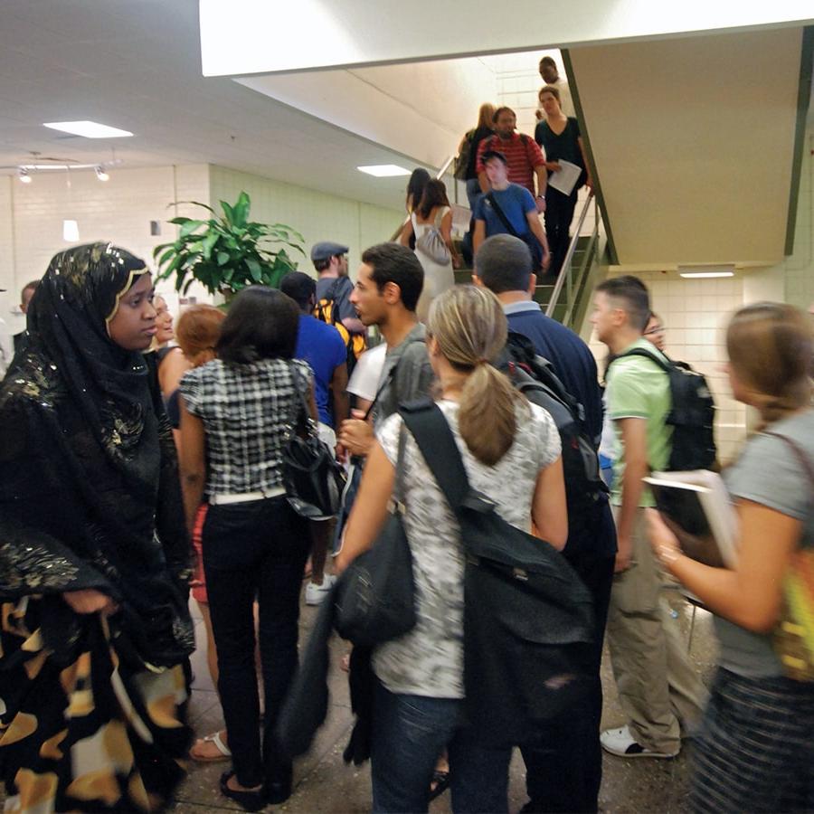 Crowd of students walk in hallway.